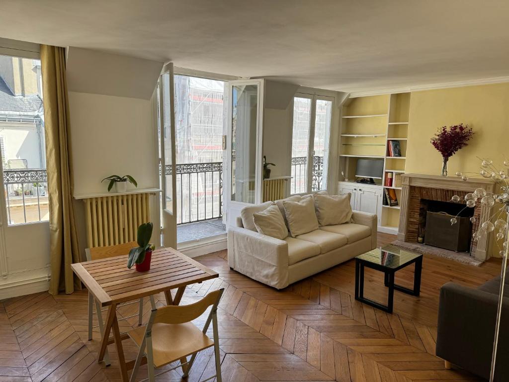 un salon avec un canapé et une table dans l'établissement Arc de Triomphe - Champs Elysées - Super emplacement - 5è étage - balcon - 60 m2, à Paris