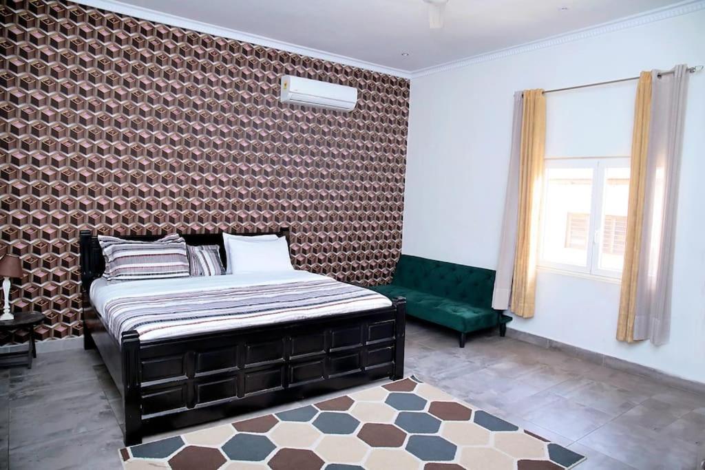 a bedroom with a bed and a green bench at Welcoming abode in the heart of Osu - Apartment 3 in Accra