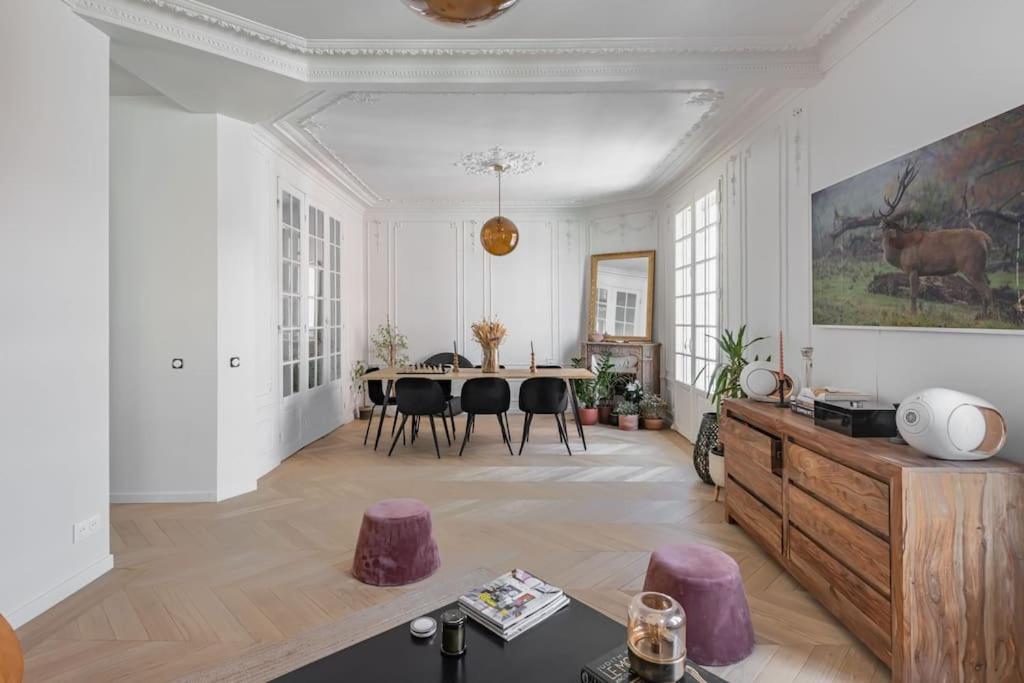 un grand salon avec une table et des chaises dans l'établissement Très bel appartement sur Vanves, à Vanves