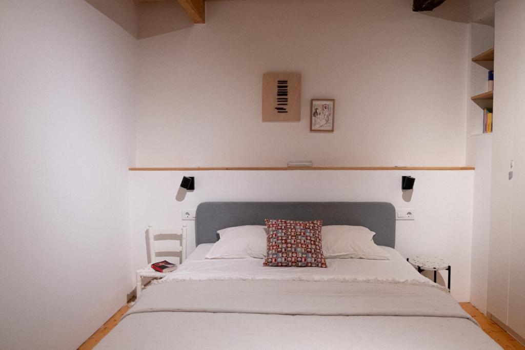 a bedroom with a white bed with a pillow on it at Cosy flat, heart of the city in A Coruña