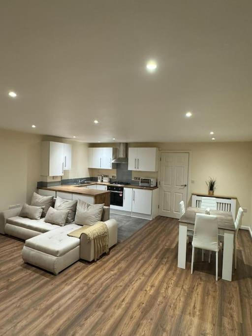 sala de estar con sofá, mesa y cocina en 2 Bedroom London Apartment, en South Norwood