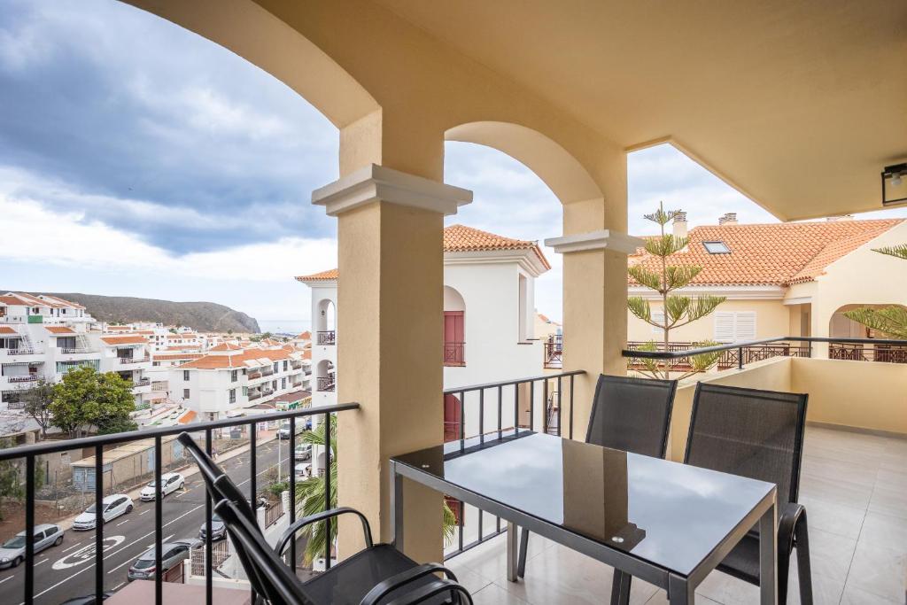 d'un balcon avec une table et des chaises offrant une vue sur la ville. dans l'établissement Luxury Family Home Heated Pool by LoveTenerife, à Los Cristianos