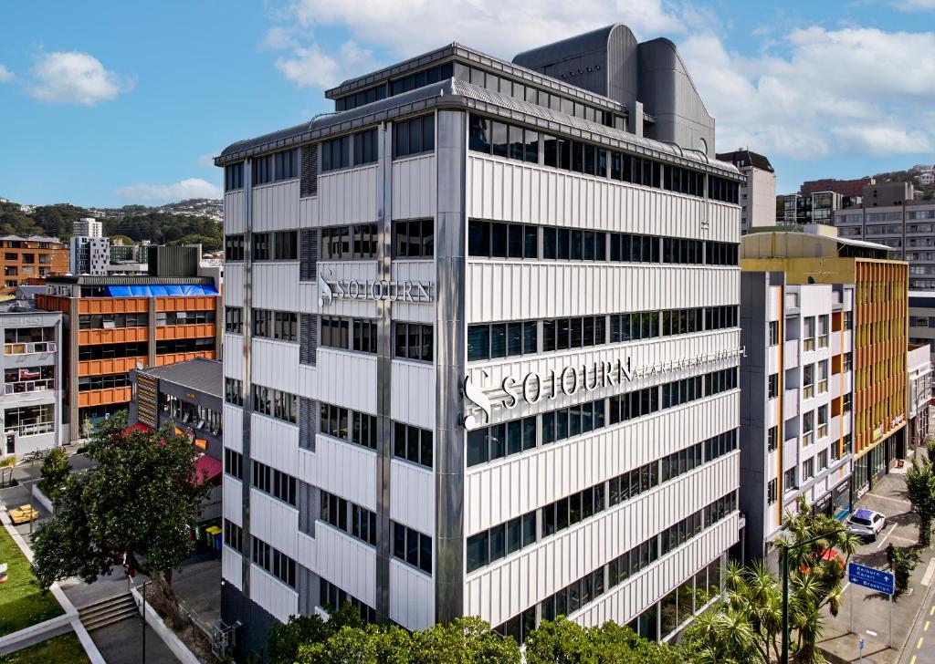 a tall white building with a sign on it at Sojourn Apartment Hotel - Ghuznee in Wellington