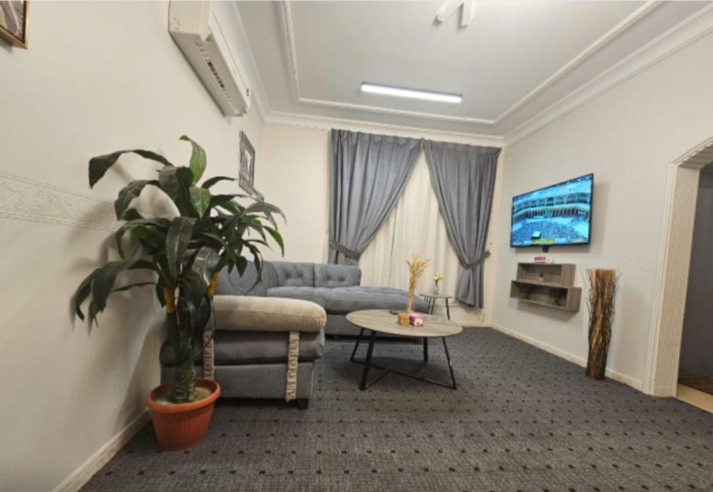 a living room with a couch and a tv at استيديو حياة الفيصلية دخول وخدمة ذاتيه in Al Rass