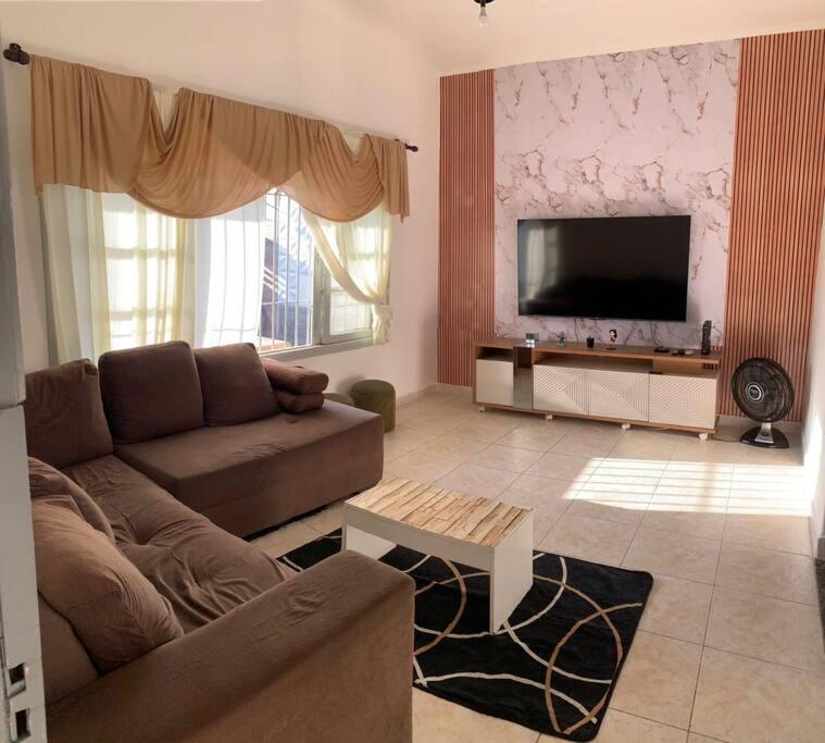 sala de estar con sofá y TV de pantalla plana en Recanto Caiçara en Solemar