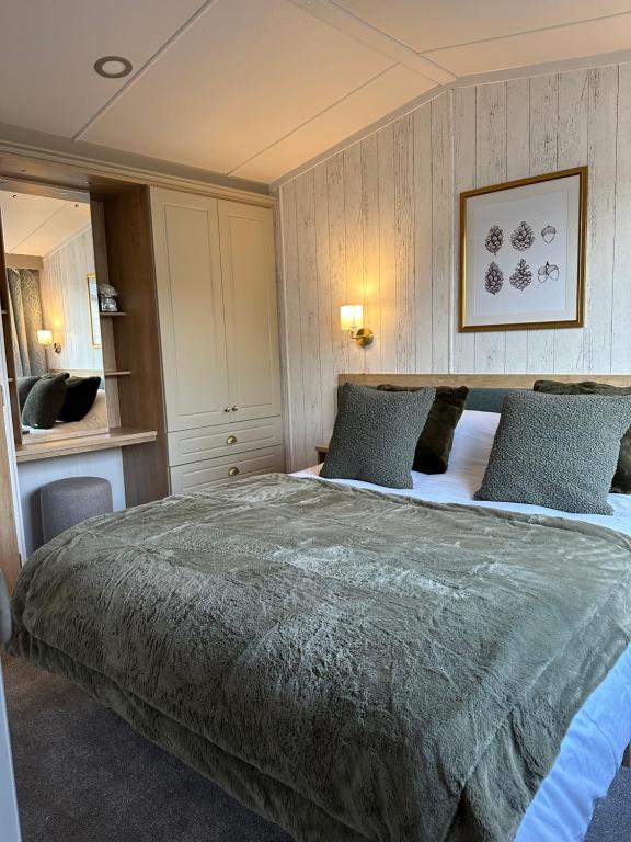 a bedroom with a large bed with blue pillows at Luxury Lakeside Lodge, Hot Tub & Private Fishing in Tattershall