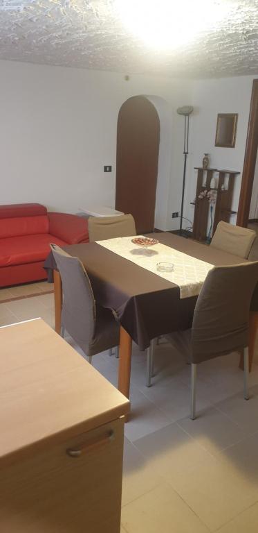 un soggiorno con tavolo e divano rosso di Nido a Parma