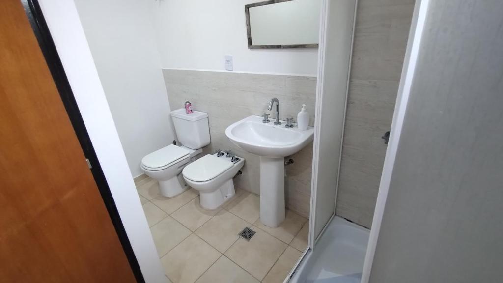 een badkamer met een toilet en een wastafel bij Depto Lionel in Río Gallegos