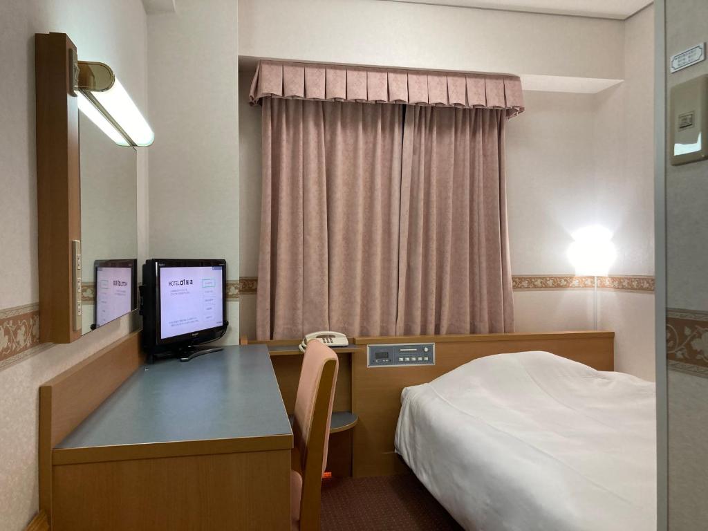 Cette chambre comprend un lit et un bureau avec un ordinateur. dans l'établissement Hotel Alpha-One Onomichi, à Onomichi