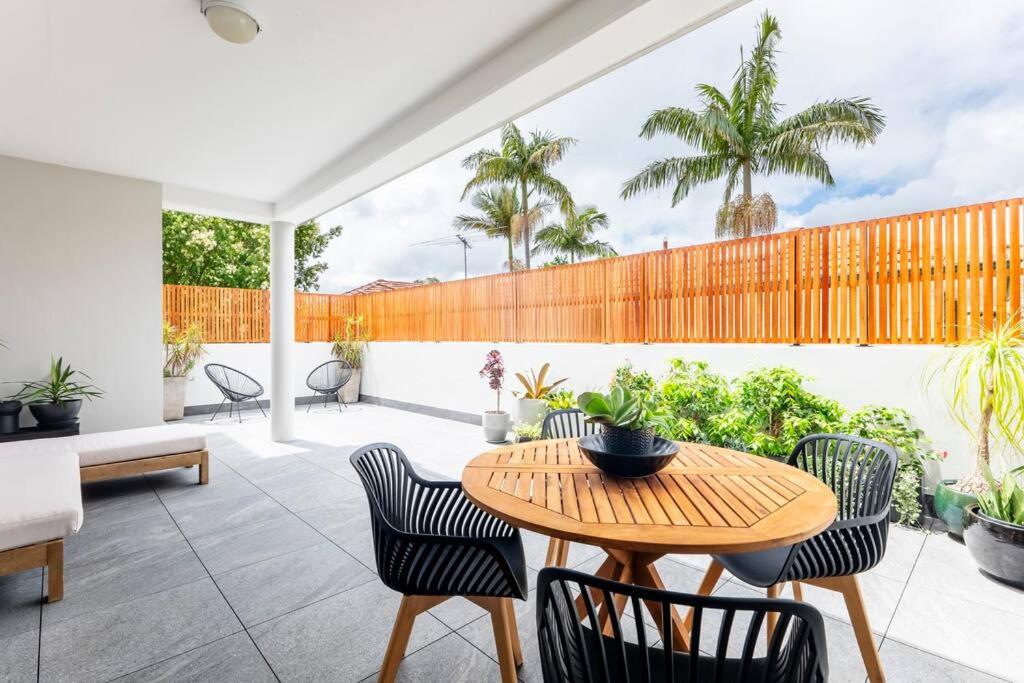 eine Terrasse mit einem Holztisch und Stühlen in der Unterkunft Balmain Designer 1 Bedroom Apartment with Parking in Sydney