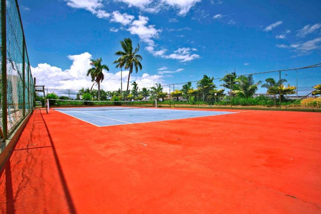 a tennis court with a net and palm trees at Fiji Gateway Hotel in Nadi