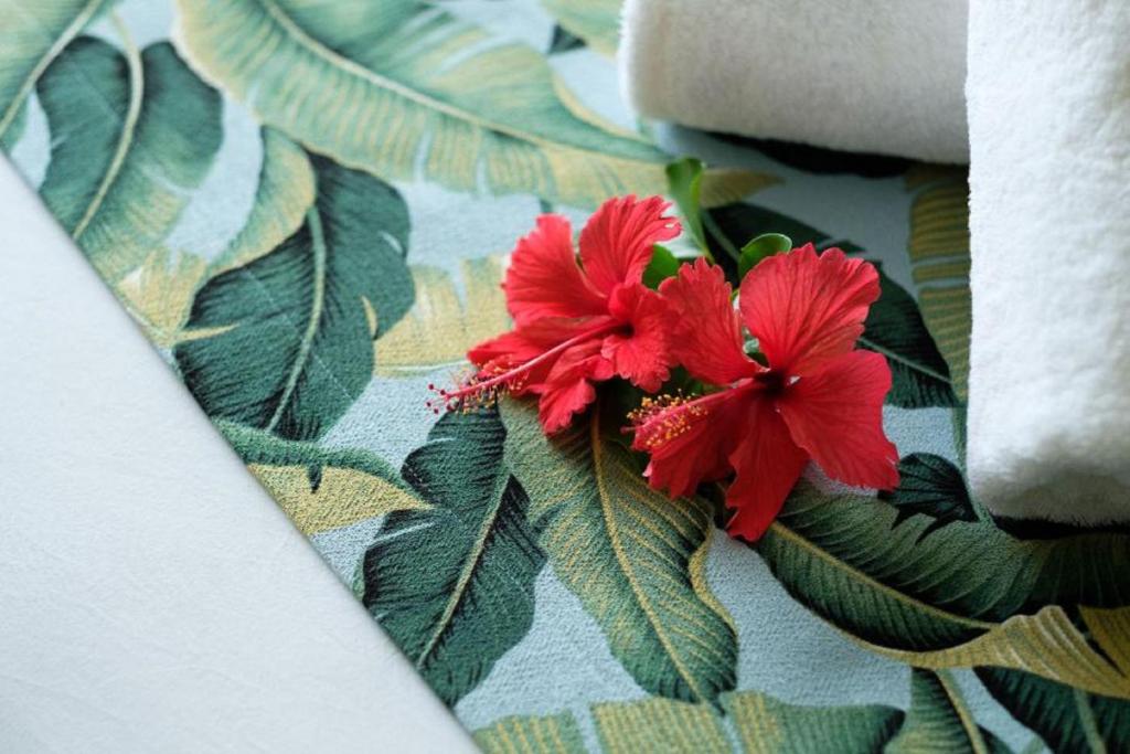 a red flower on a cloth with green leaves at Fiji Gateway Hotel in Nadi