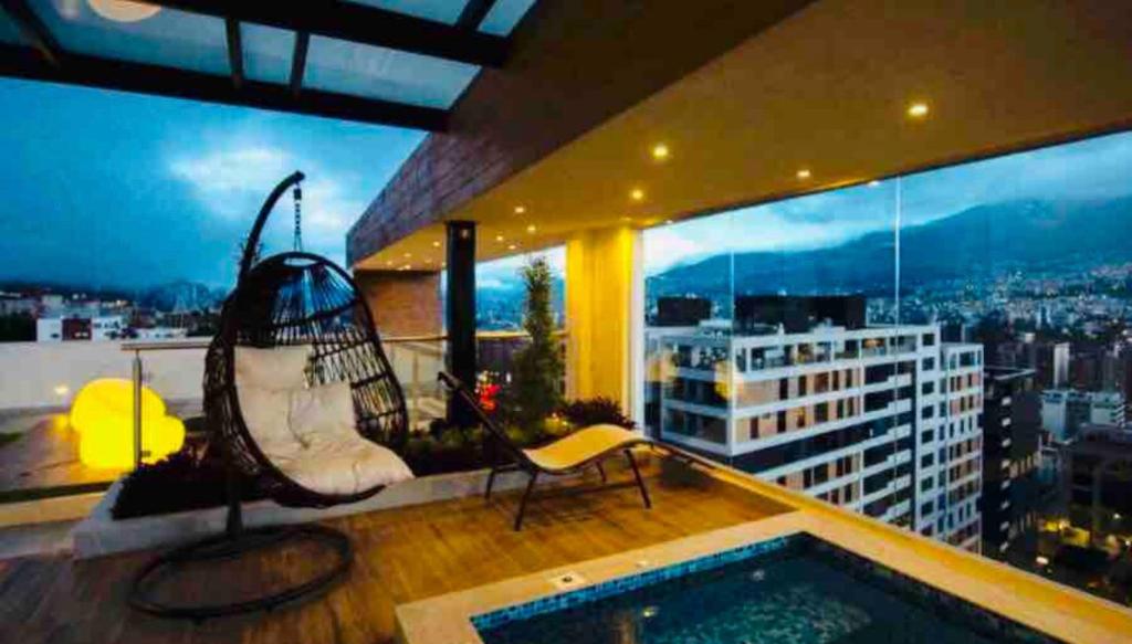 a balcony with a swing and a pool on a building at Exclusivo alojamiento, excelente vista y ubicación in Quito