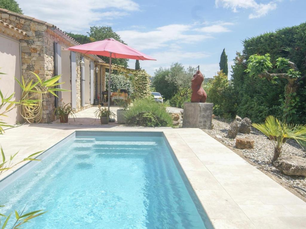 einen Pool im Garten mit Sonnenschirm in der Unterkunft Villa des Arts in Draguignan