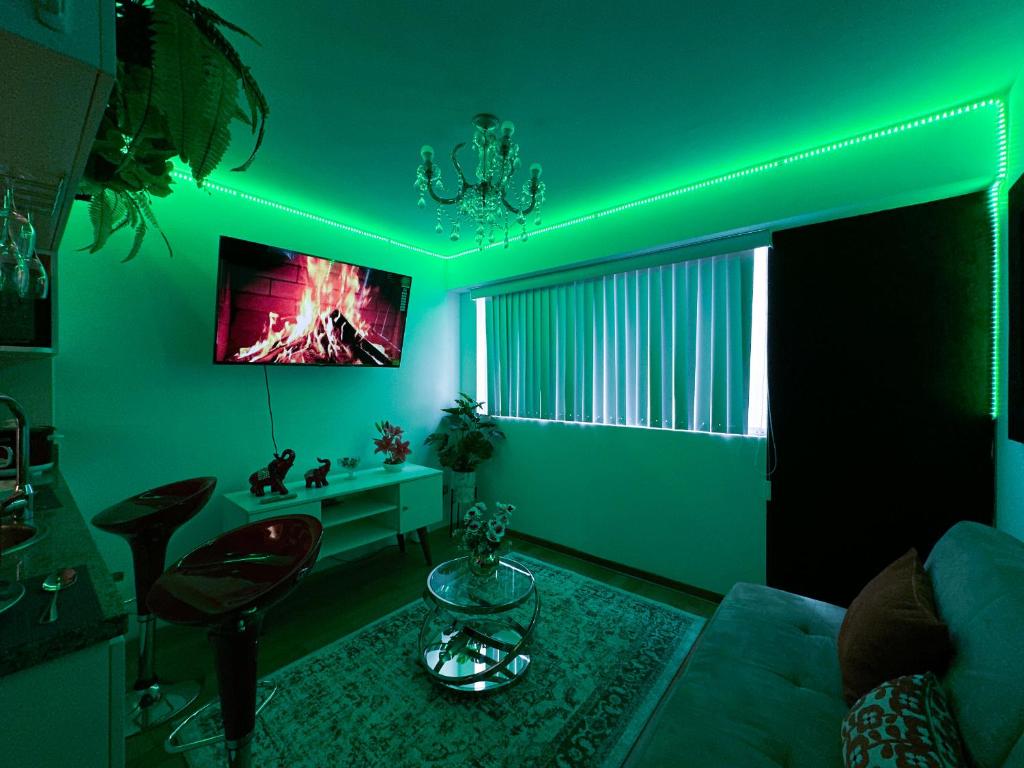 uma sala de estar com iluminação verde e um sofá em Apartamento Acogedor - BARRANCO em Lima