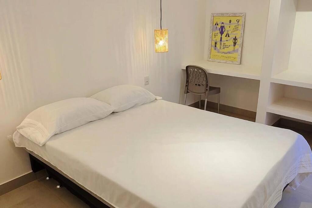 聖米格爾－杜戈斯托蘇的住宿－Casa Madá，一张大白色的床,位于带椅子的房间