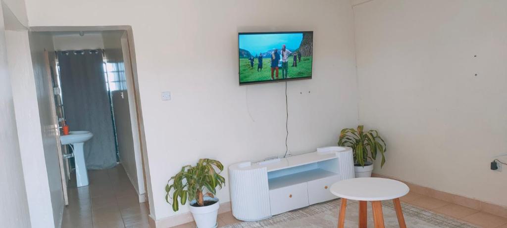 a living room with a tv on the wall at Fancy One Bedroom Juja in Juja