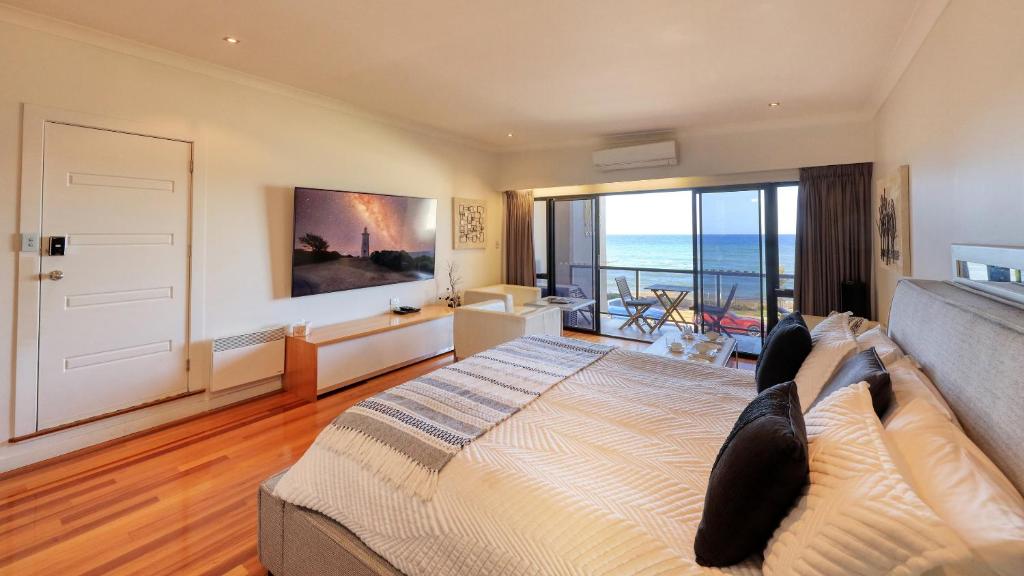 a bedroom with a bed and a view of the ocean at The Madsen Boutique Hotel in Penguin
