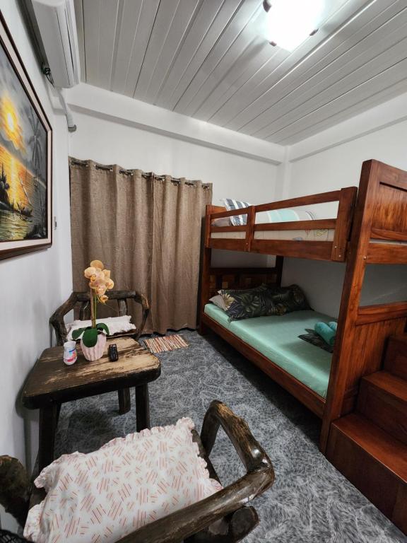 a bedroom with two bunk beds and a table at ASHBURN'S TRANSIENT Bauang La Union - MOTORCYCLE PARKING ONLY in Lossoc