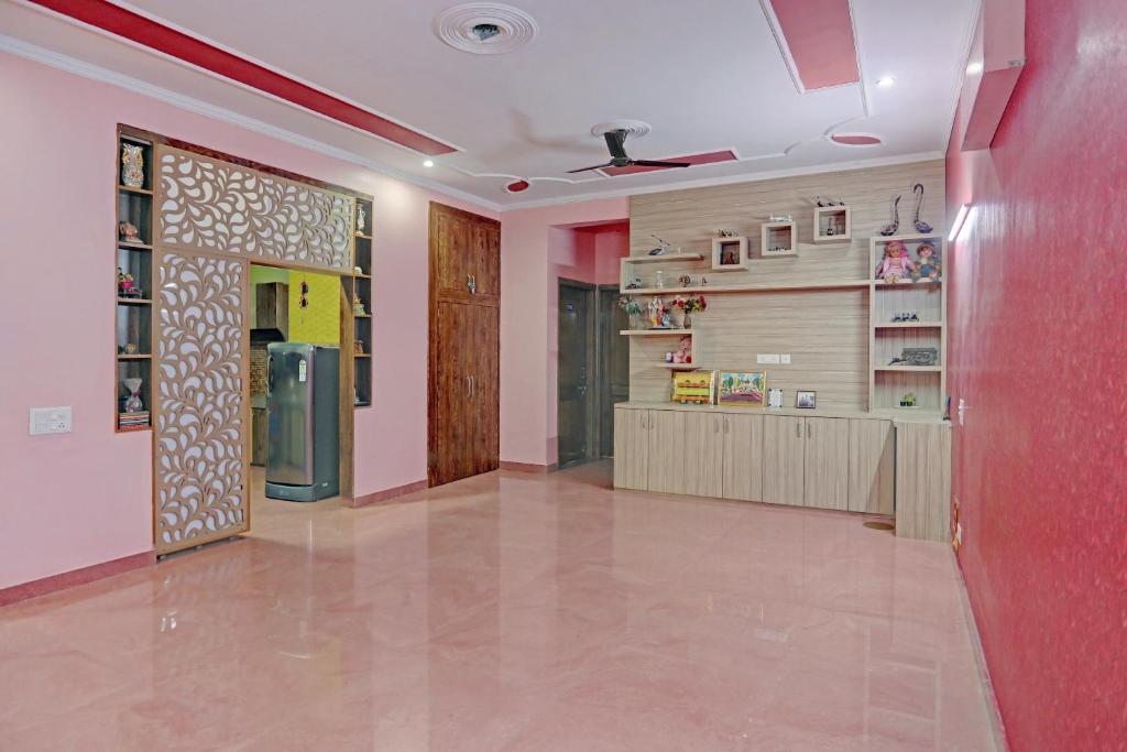 un pasillo de una casa con una pared roja en OYO Stay 130, en Noida