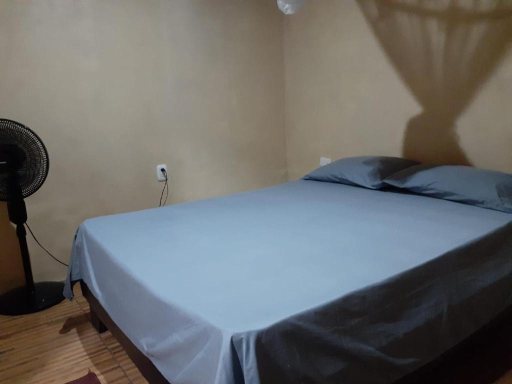 białe łóżko w pokoju z wentylatorem w obiekcie Casa Palos Verdes w mieście Puerto Viejo