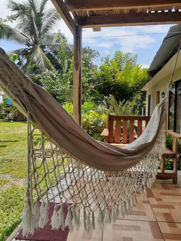 a hammock on the porch of a house at Casa Palos Verdes in Puerto Viejo