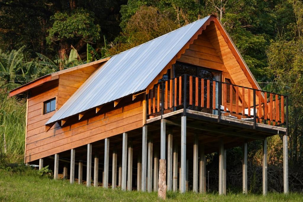 una casa con techo de gambrel con terraza en Cabaña Indira, en Monteverde
