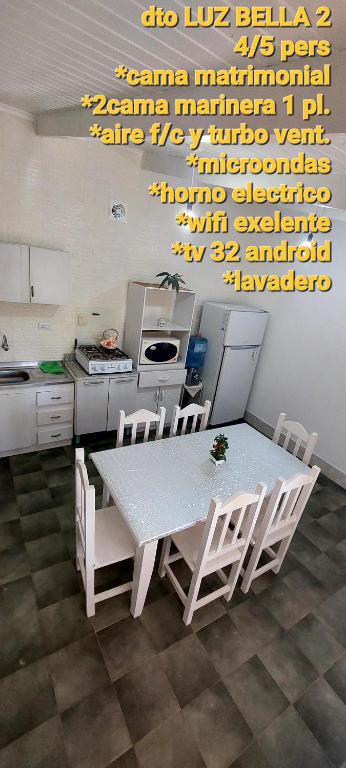 a kitchen with a table and chairs in a kitchen at LUZ BELLA 2 in Oberá