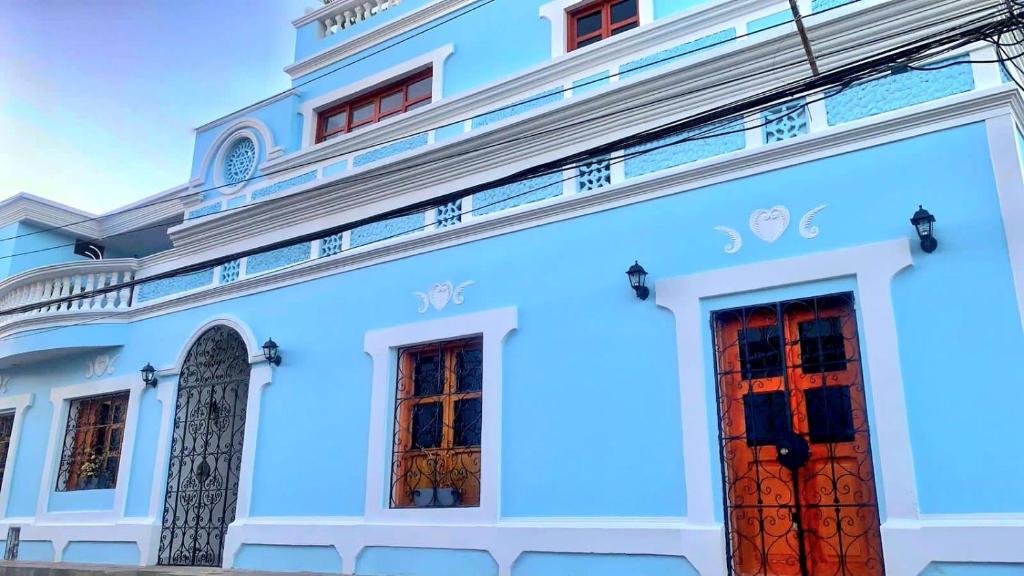 un edificio azul con dos puertas rojas en Luna Nueva Casa de Huéspedes, en Ríohacha