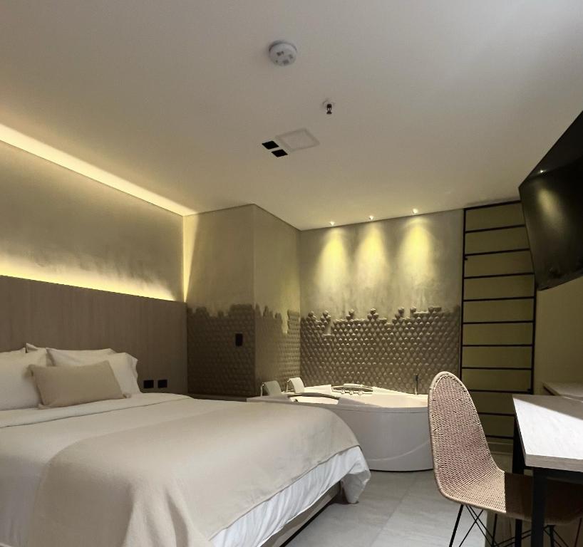 a hotel room with a bed and a bathtub at Sonata 44 Hotel Laureles in Medellín