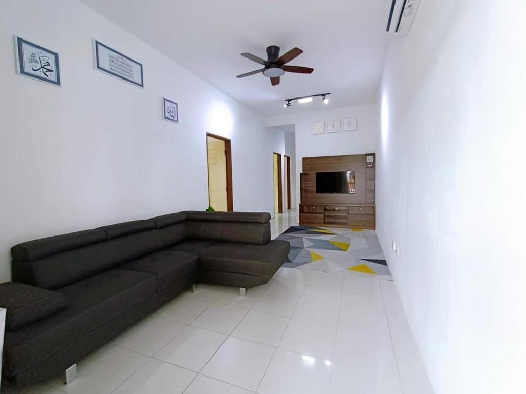 uma sala de estar com um sofá e uma ventoinha de tecto em Manjung Point Homestay em Seri Manjung