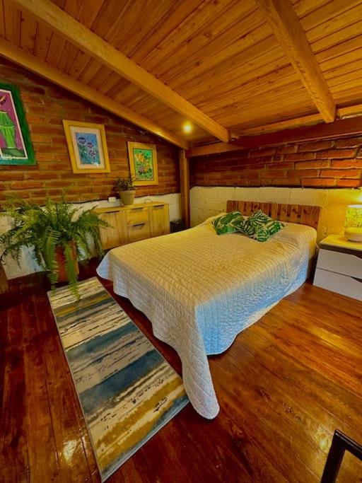 a bedroom with a bed in a wooden room at Casa del árbol - Mitad del mundo in Quito