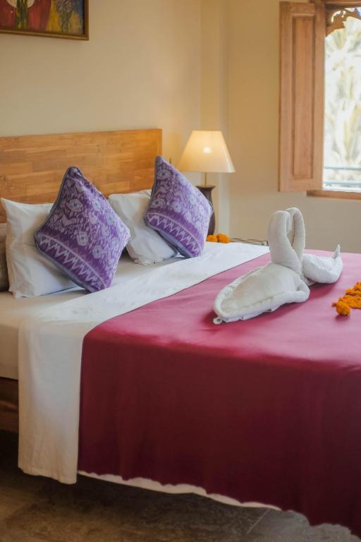 Postel nebo postele na pokoji v ubytování Nirwa 1 Ubud Guesthouse