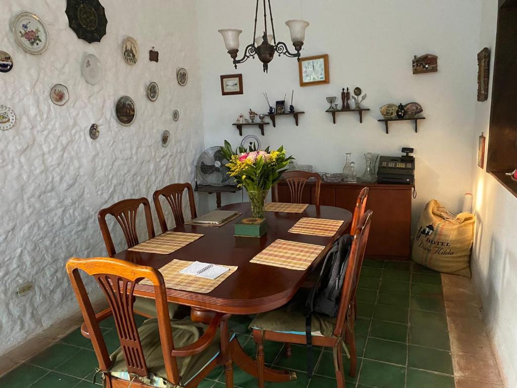 uma sala de jantar com uma mesa de madeira e cadeiras em Hotel Doña Hilda em San Martín