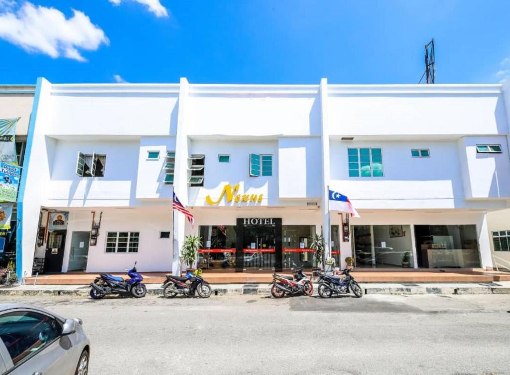 una fila de motocicletas estacionadas frente a un hotel en Nexus Hotel, en Melaka