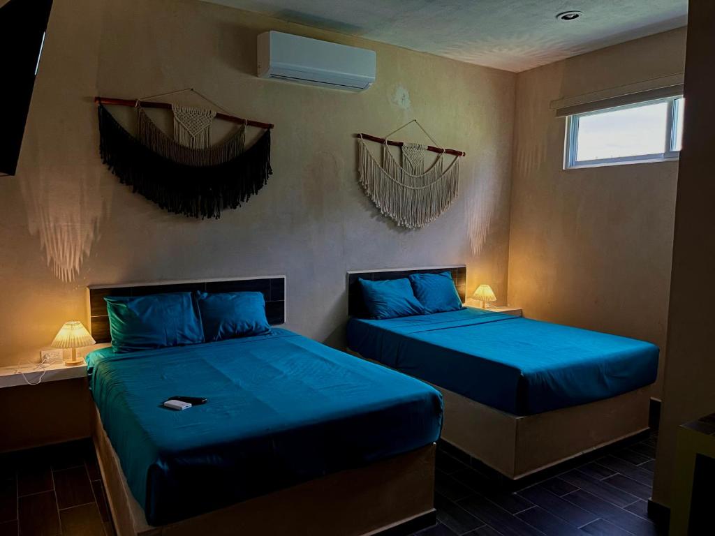 two beds in a room with blue sheets at Casa Fausto’s in Azcorra