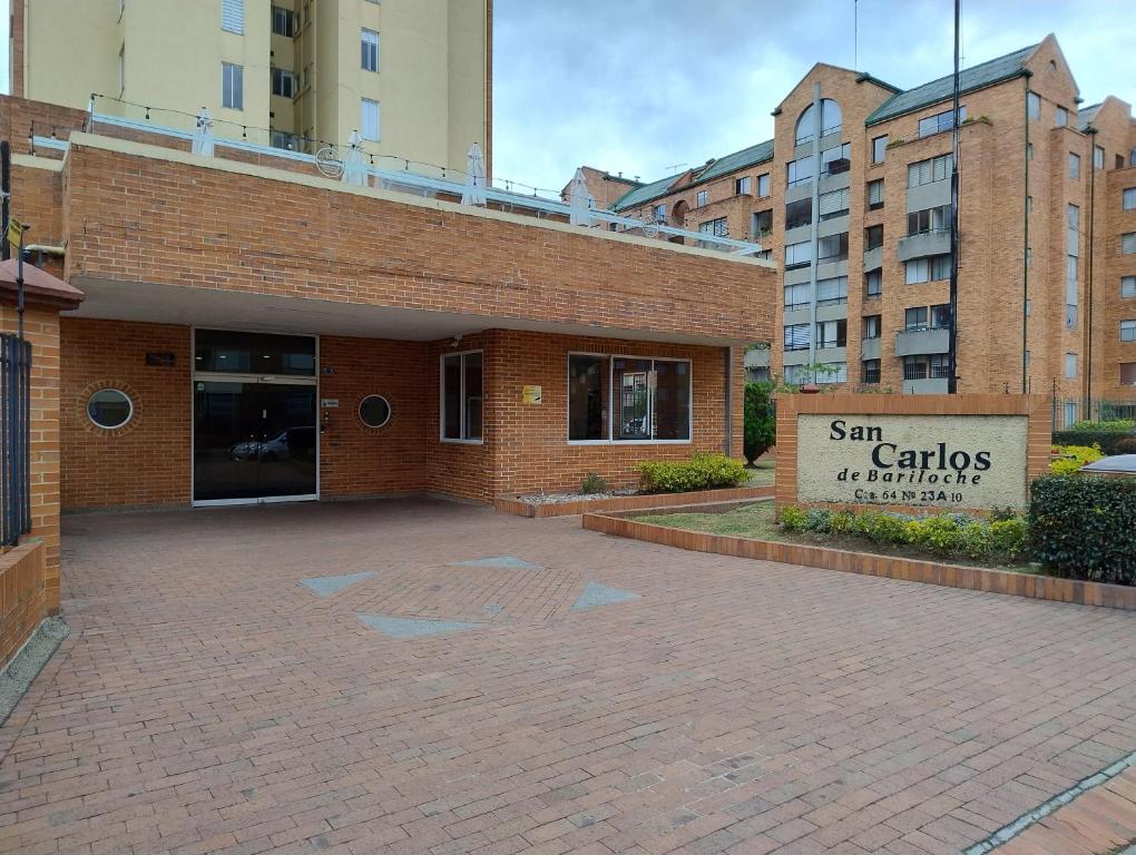 un edificio in mattoni con un cartello che legge gli appartamenti di San Carlos Garços di Apartamento Amoblado a Bogotá