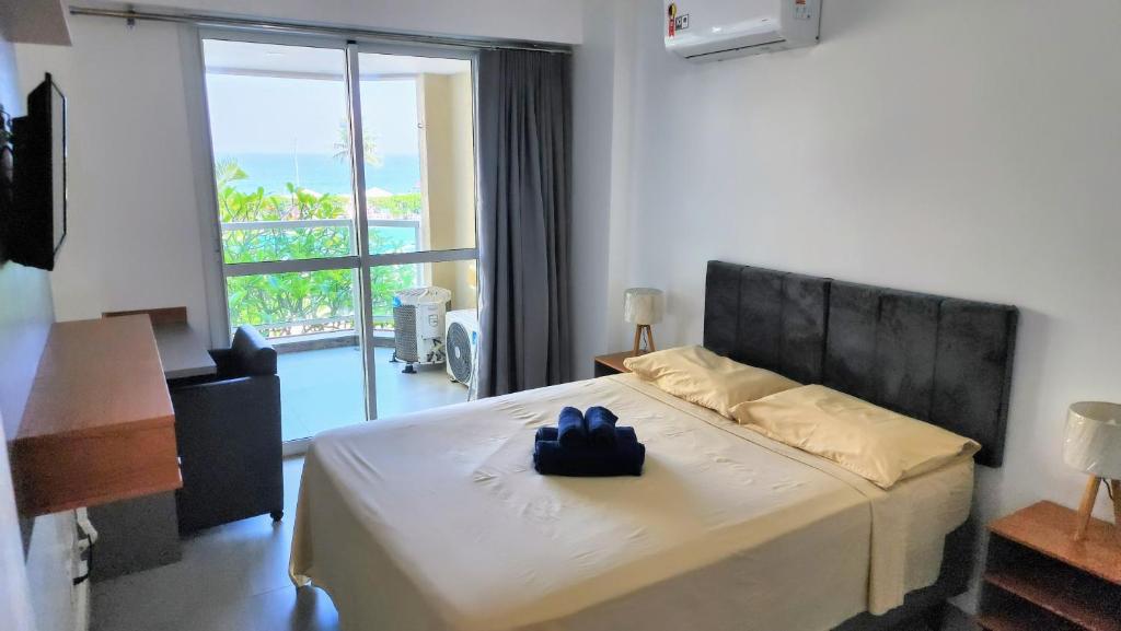1 dormitorio con 1 cama y vistas a un balcón en Vista Mar em Villa del Sol Residences - unidade autônoma, en Río de Janeiro