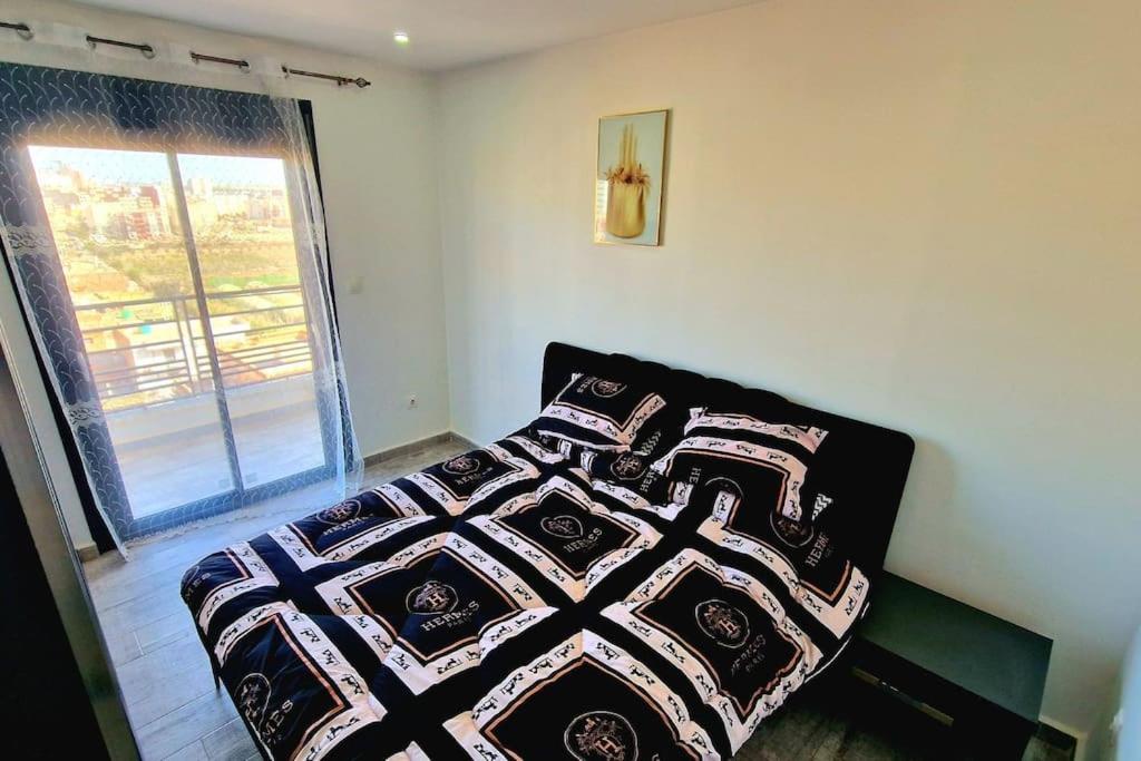 sypialnia z łóżkiem z kołdrą w obiekcie F3 millenium w mieście Oran