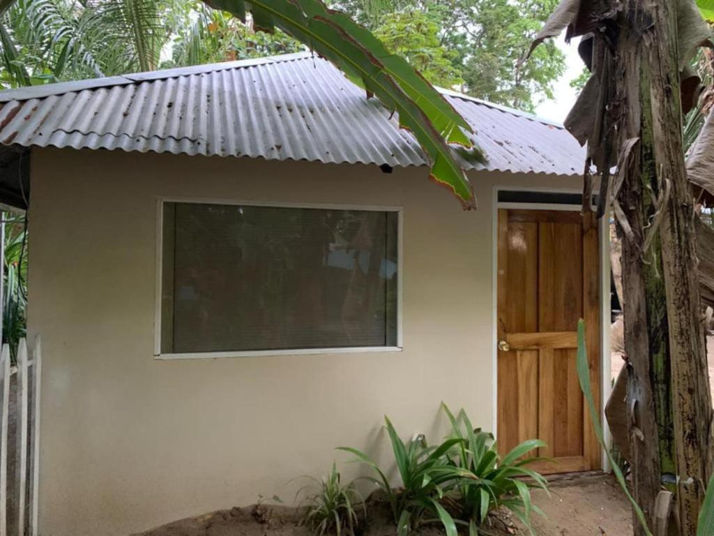 a small house with a door and a tree at Finca del Mar Frente la Playa Room 4 in Puerto Viejo