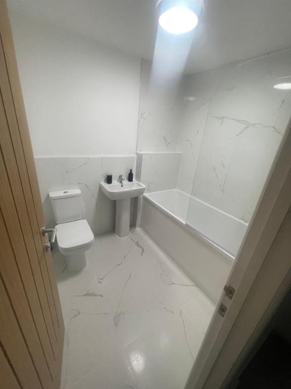 a white bathroom with a toilet and a sink at Room in Bourne in Lincolnshire