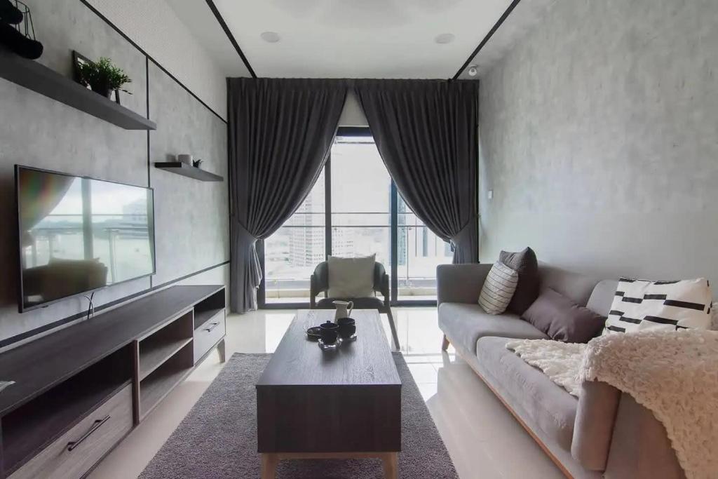 - un salon avec un canapé et une télévision dans l'établissement A Cozy & Lovely High-Floor 3BR Suite City Views, à Johor Bahru