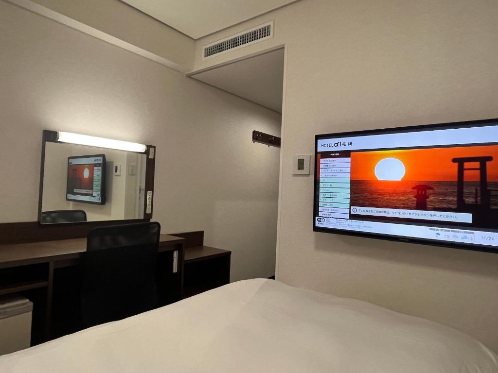 pokój hotelowy z łóżkiem i telewizorem z płaskim ekranem w obiekcie Hotel Alpha-One Kashiwazaki w mieście Kashiwazaki