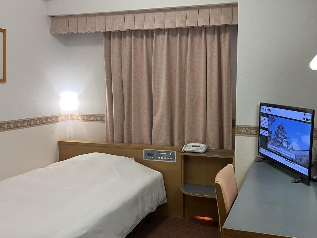 a hotel room with a bed and a flat screen tv at Hotel Alpha-One Aizuwakamatsu in Aizuwakamatsu