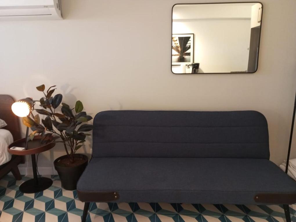 eine blaue Bank in einem Zimmer mit Spiegel in der Unterkunft Apartamento Casco Antiguo in Panama-Stadt