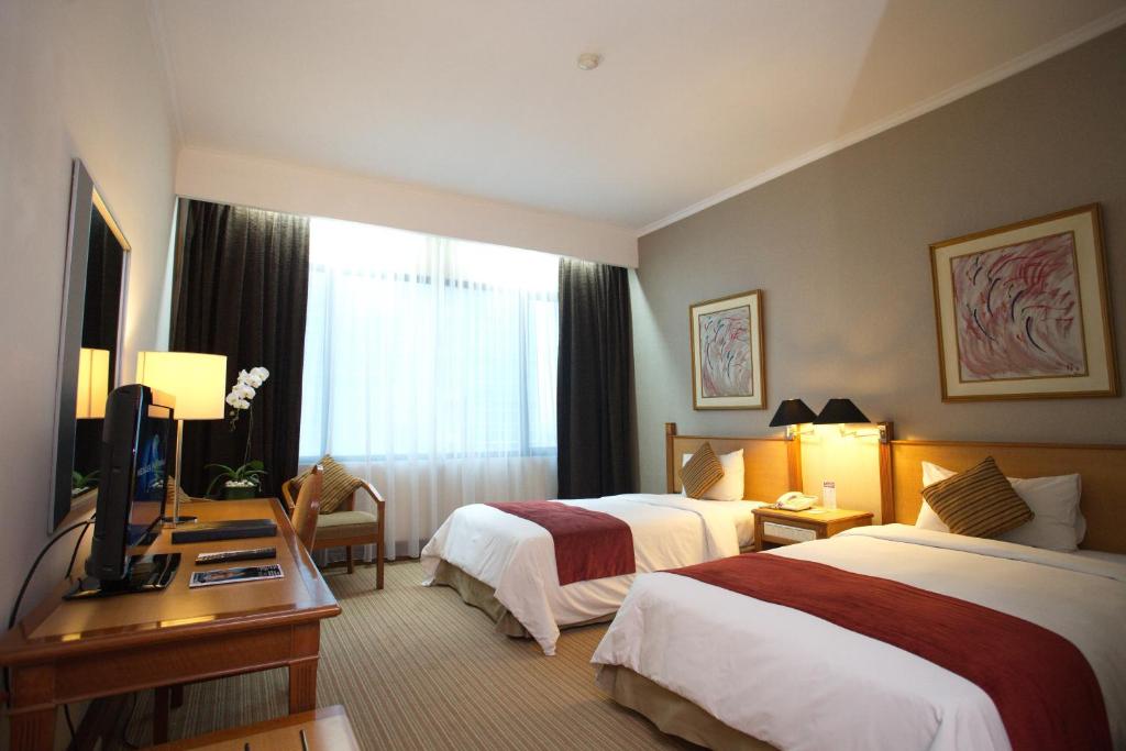 Postel nebo postele na pokoji v ubytování Menara Peninsula Hotel
