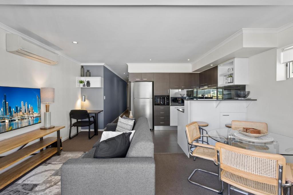 - un salon avec un canapé et une table dans l'établissement Private 2-Bed Apartment & 5 minutes walk to QPAC, à Brisbane