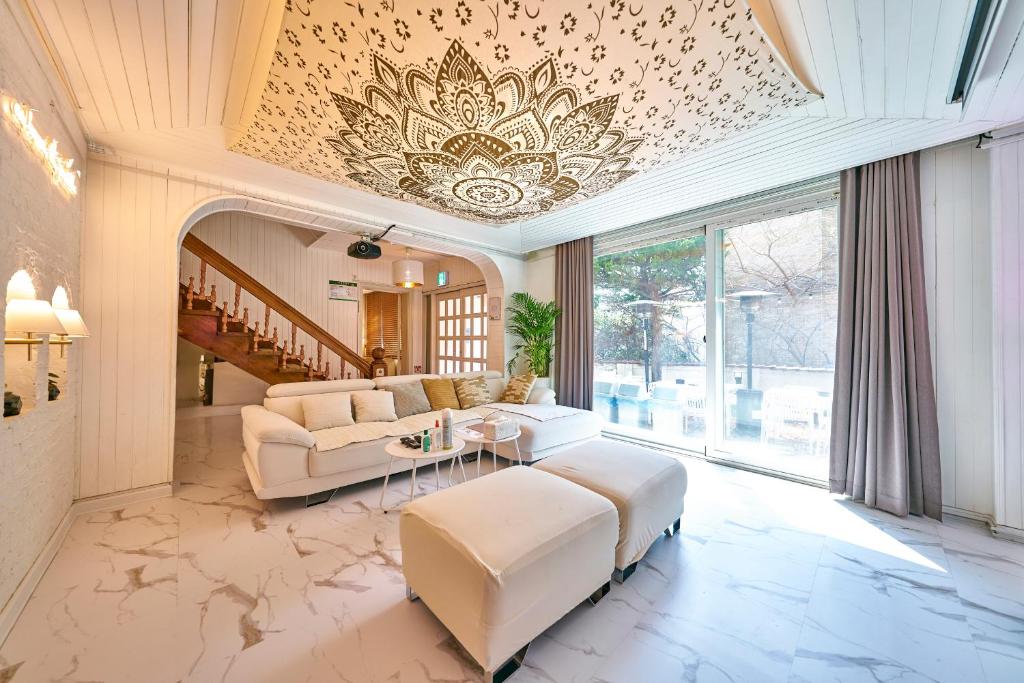 a living room with white furniture and a fancy ceiling at Sg Tailored Serviced Home 5min Walk From Metro in Seoul