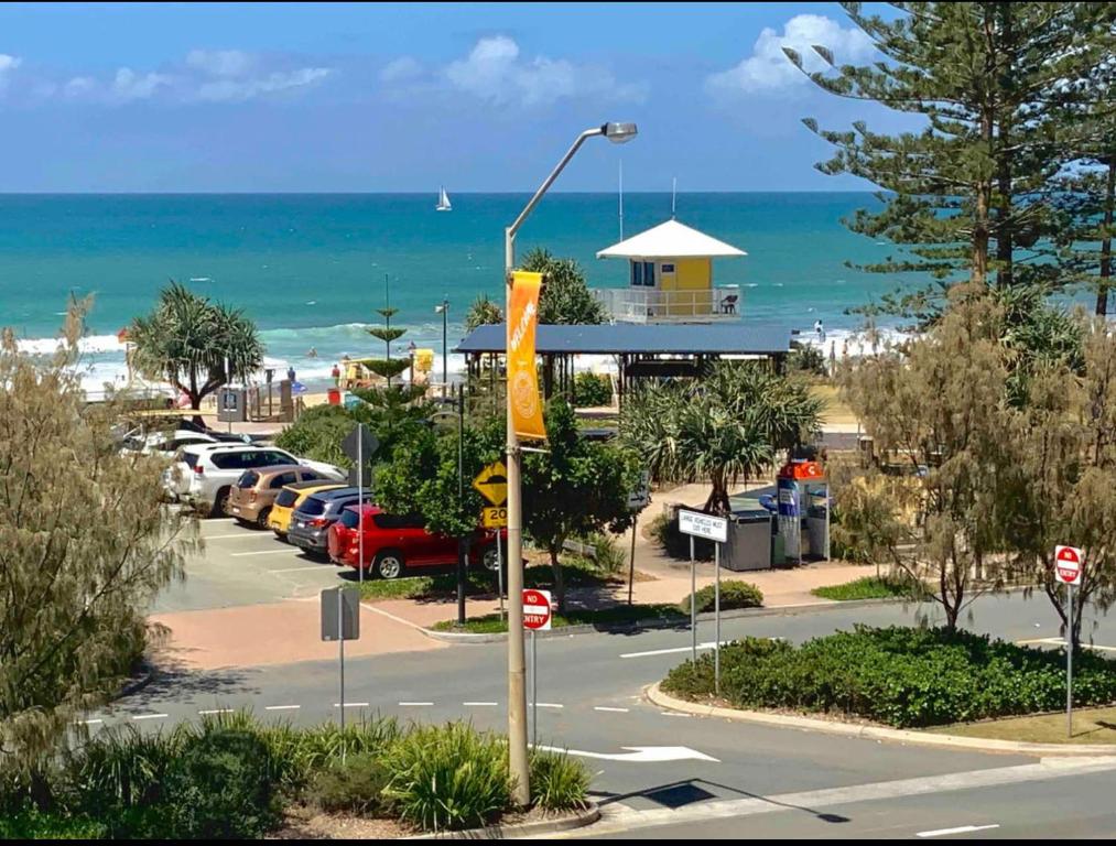 um parque de estacionamento ao lado de uma praia com o oceano em Ocean View - Alexandra Headlands Beachfront Unit em Alexandra Headland