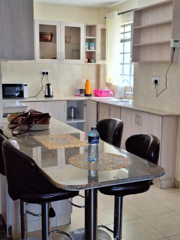 a table in a kitchen with a bottle of water on it at Luxury Homes in Nairobi in Athi River